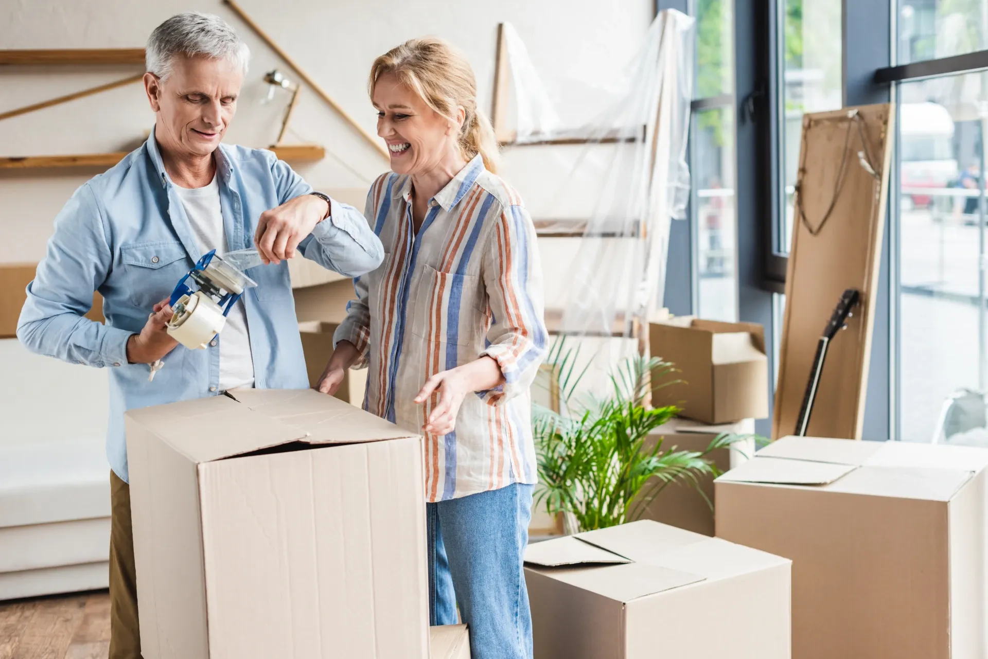 Couple taping up a moving box